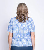 Load image into Gallery viewer, Woman wearing a blue floral top and navy pants on a white background
