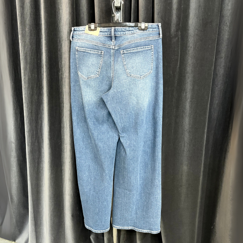 Light blue jeans hanging against a plain background