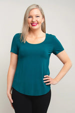Load image into Gallery viewer, Woman wearing a teal shirt against a plain background
