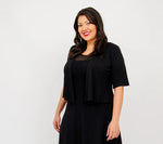 Load image into Gallery viewer, Woman wearing a black dress with sheer overlay on a white background
