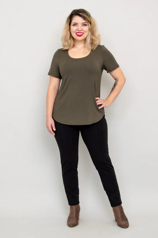 Woman wearing an olive green t-shirt and black pants on a white background