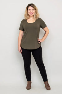 Woman wearing an olive green t-shirt and black pants on a white background